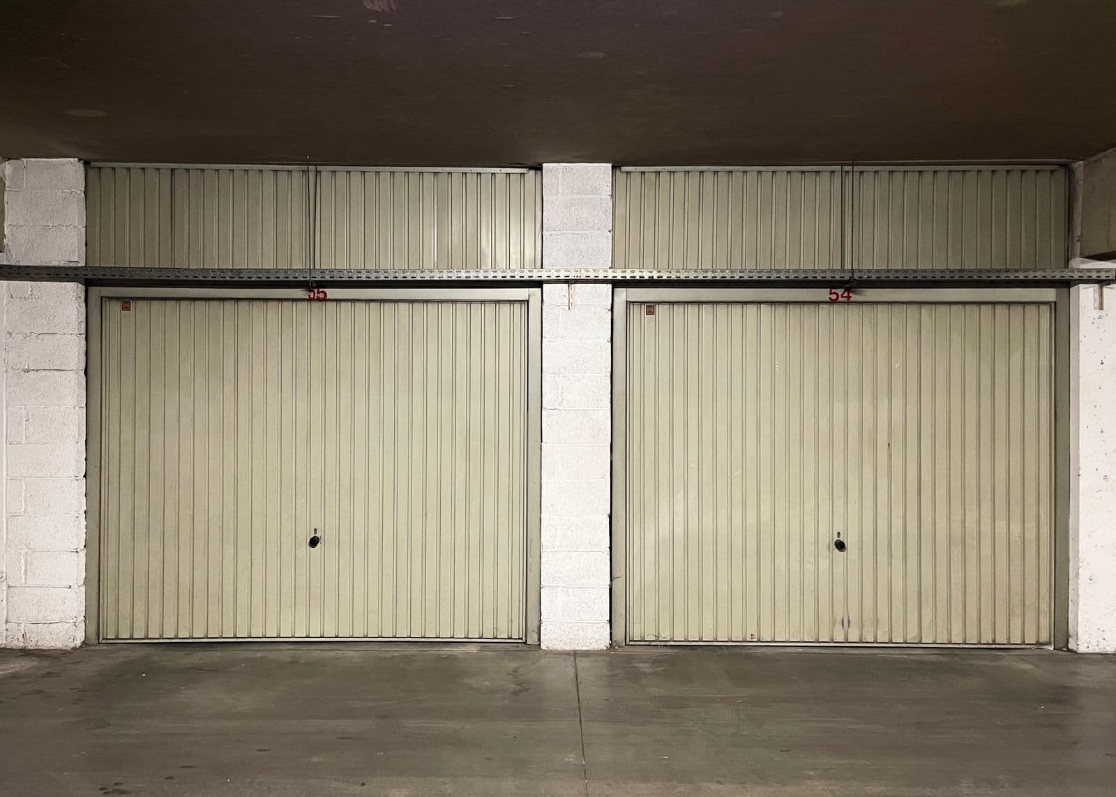 Two closed garage doors over a plain concrete slab